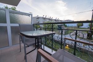 a balcony with a table and chairs on a balcony at acquablue apartments in Kallithea Halkidikis