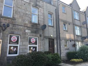 a building with four signs on the side of it at Pineapple Apartments in Aberdeen