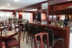 a bar in a restaurant with tables and chairs at Hotel Obino Bagé in Bagé