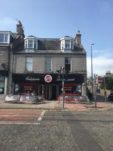 a building on the corner of a street with a store at Pineapple Apartments in Aberdeen +11 photos