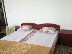 a bed with two pillows on top of it at Guest House Neli in Nesebar