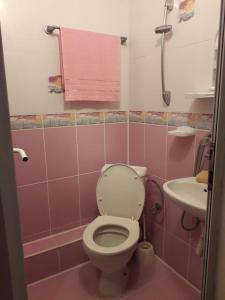 a pink bathroom with a toilet and a sink at Guest House Neli in Nesebar +29 photos