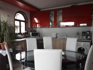a kitchen with a glass table and white chairs at Guest House Neli in Nesebar