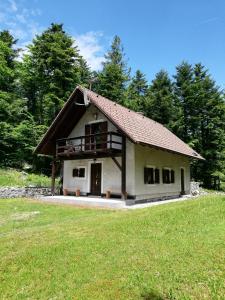 a small white house with a porch on a field at Guest House Nanos in Vipava +13 photos