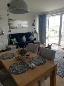 een woonkamer met een houten tafel met een kat eromheen bij Apartament na Morskim Wzgórzu in Mechelinki