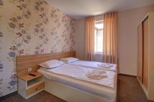 Habitación pequeña con cama y ventana en Hotel Mida en Obzor