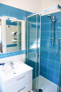 W łazience znajduje się umywalka i prysznic z niebieskimi kafelkami. w obiekcie b&b binario nove e tre quarti w Agropoli