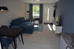 a living room with a blue couch and a table at Einemo Apartments in Lærdalsøyri