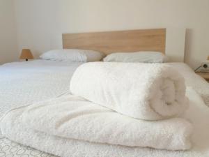 two white towels are stacked on a bed at Apartments Lazarević in Kotor