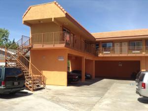 a large house with a staircase in a parking lot at Coast Motel in Long Beach