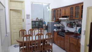 una cucina con tavolo, sedie e frigorifero di Homestay Nam Dong a Hanoi