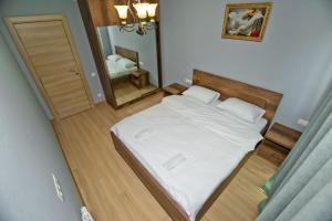 1 dormitorio con cama blanca y espejo en Orbi Bakuriani apartment 729 en Bakuriani