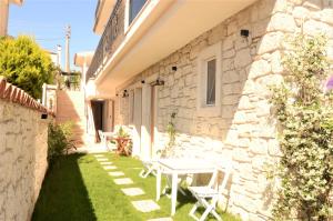 a small yard with a white table and chairs at Grand Alaçatı Butik Hotel in Alaçatı