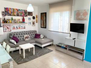 a living room with a couch and a tv at Acquamarina Apartment in Marzamemi