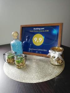 a table with three glass jars and a picture at Apartment Sun & Sea in Krk