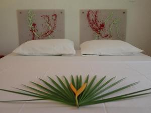 a bed with two pillows and a plant on it at Simberts Apartments in Maya Beach