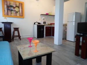 a living room with a table with two wine glasses on it at Simberts Apartments in Maya Beach