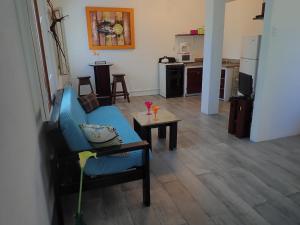 a living room with a blue couch and a table at Simberts Apartments in Maya Beach