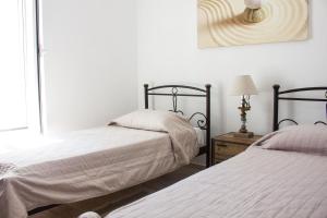 a bedroom with two beds and a lamp on a table at Blue Island in Batsi