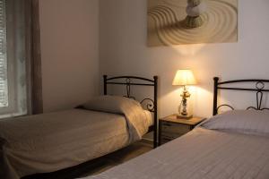 a bedroom with two beds and a lamp on a table at Blue Island in Batsi