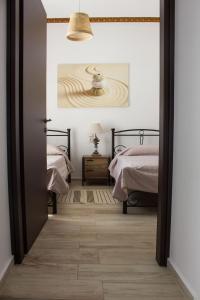 a bedroom with two beds and a door leading into a room at Blue Island in Batsi