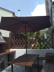 un paraguas negro sentado en una mesa de picnic en Anthi Apartment, en Palaión Tsiflíkion