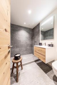 ein Badezimmer mit einem Waschbecken, einem WC und einem Stuhl in der Unterkunft Unique Alpic style apartment in the heart of Davos in Davos