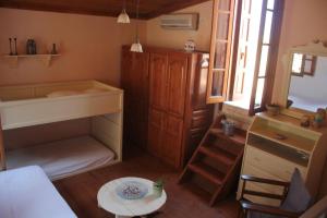 a small room with a bed and a desk and a table at Astradeni in Symi