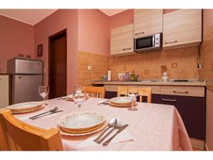 a kitchen with a table with plates and wine glasses at Apartman Nensi in Vodnjan