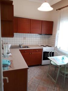 a kitchen with brown cabinets and a white stove top oven at Iraklitsa bay apartment in Iraklitsa