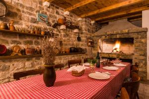 a dining room with a table with a red and white checkered table cloth at Holiday home Ante with beautiful private garden in Nadin