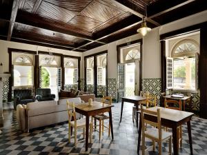 a living room with a couch and tables and chairs at Train Spot Guesthouse in Marvão