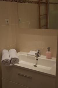 uma casa de banho com lavatório, toalhas e espelho em Nice centre- Superbe 100m2 - 10 mn à pied de la mer ! em Nice