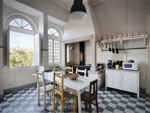 a kitchen with a table, chairs, and a window at Train Spot Guesthouse in Marvão