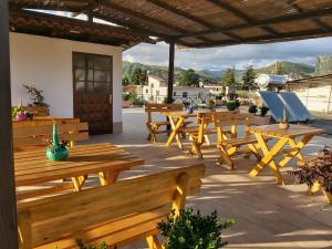 a group of wooden tables and benches on a patio at bed & breakfast Local Living Edi in Berat