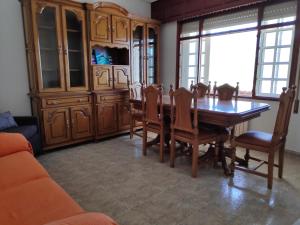 uma sala de jantar com uma mesa de madeira e cadeiras em Casa en primera linea de playa en Pantin!! em Pantín