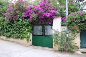 una porta verde con fiori viola su un edificio di Villino Rosetta a Mondello