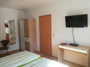 Un dormitorio con una cama y un televisor de pantalla plana. en Ferienwohnung Düne, en Ostseebad Sellin