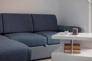 a living room with a blue couch and a white table at Villa Apartments Kordić in Kaštela