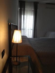 a bedroom with a bed with a lamp next to a window at Paradiso in Marina di Carrara