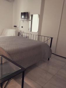 1 dormitorio con cama, mesa y espejo en Paradiso en Marina di Carrara