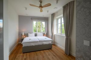 a bedroom with a bed and a ceiling fan at Vila Ula La Luxury Apartments in Bled