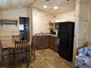 a kitchen and dining room with a refrigerator and a table at Castle Gate RV Park in Helper