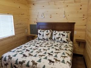 Schlafzimmer mit einem Bett mit einer Daunendecke und Hirschdrucken in der Unterkunft Castle Gate RV Park in Helper