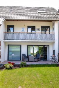 a house with a patio and a balcony at Ferienappartement Hennen in Konz
