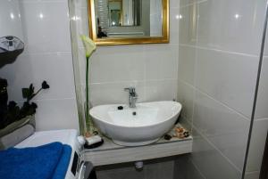 a bathroom with a white sink and a mirror at Parva Villa in Miskolc