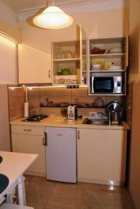 a small kitchen with a sink and a microwave at Parva Villa in Miskolc