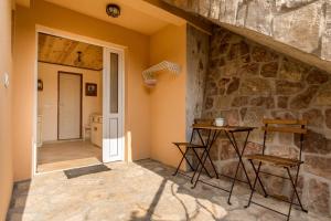 Habitación con pared de piedra, mesa y sillas. en Guest House Luna en Virpazar