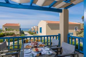 - une table avec de la nourriture sur un balcon avec vue sur l'océan dans l'établissement Evgenia Residences, à Agios Ioannis Kaspaka