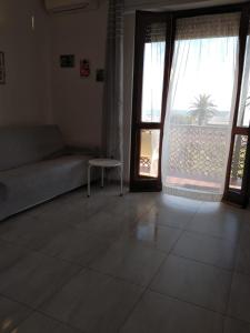 a living room with a couch and two large windows at Paradiso in Marina di Carrara